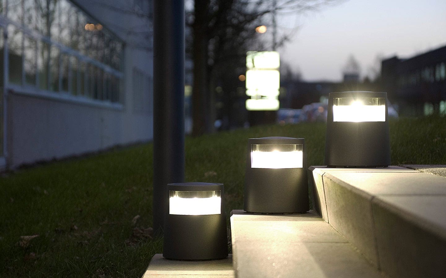 Hoffmeister Minipoller leuchten in der Dämmerung an einem Gehweg